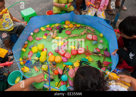 Auf einem Straßenmarkt in der Nähe des Heroes Monument in Surabaya, Ost-Java, Indonesien, spielen Kinder auf einem kleinen Teich mit Plastikspielzeug Angelspiele. Stockfoto
