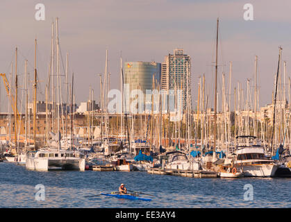 Barcelona, Spanien.  Mann Wriggen unter Luxus Yachten in Port Vell. Stockfoto