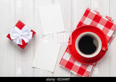 Valentinstag leere Bilderrahmen, Kaffee-Tasse und Geschenk-Box über weißer Holztisch Stockfoto