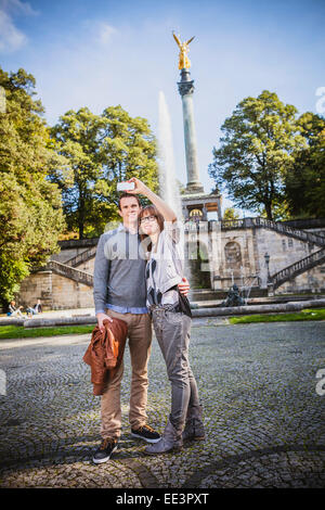 Junges Paar, wobei ein Selbstporträt gegen Angel Friedensmonument, München, Bayern, Deutschland Stockfoto