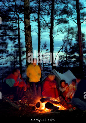 Touristen-Lagerfeuer. Menschen Sie Sitzgelegenheiten rund um des Feuers. Stockfoto