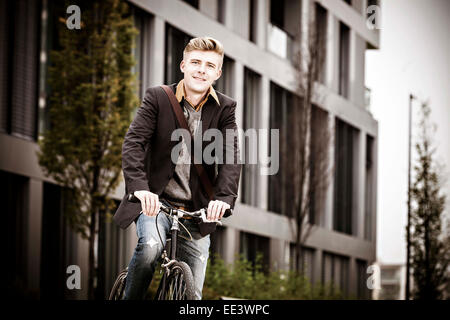 Junger Geschäftsmann mit Fahrrad, München, Bayern, Deutschland Stockfoto