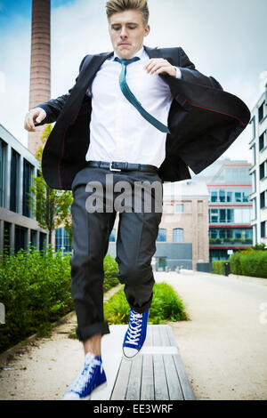 Junger Geschäftsmann springen in Luft, München, Bayern, Deutschland Stockfoto