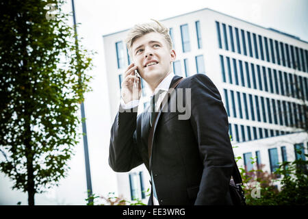 Junger Geschäftsmann mit Telefon, München, Bayern, Deutschland Stockfoto