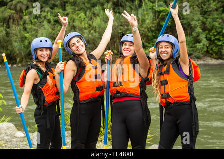 Gruppe von vier jungen Damen bereit zu gehen White Water Rafting das Tragen bestimmter Geräte Stockfoto