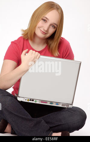 Dieses Foto zeigt einen attraktive Teenager-Mädchen sitzen und halten ihren Laptop-Computer. Stockfoto