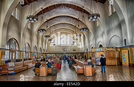 Innenraum des historischen Santa Fe Depot im Stadtzentrum von San Diego, Kalifornien, mit Passagieren, Holzbänken und der gewölbten Decke des Bahnhofs. Stockfoto