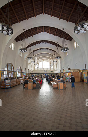 Innenraum des historischen Santa Fe Depot im Stadtzentrum von San Diego, Kalifornien, mit Passagieren, Holzbänken und der gewölbten Decke des Bahnhofs. Stockfoto
