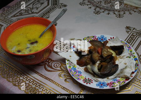 schmackhafte vegetarische Mahlzeit würzige Suppe in tief orange Bowl und Eintopf Auberginen auf dünnen Fladenbrot Stockfoto