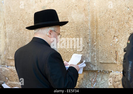 Ein jüdischer Mann liest aus einem Papier vor der Westwand in der Altstadt von Jerusalem Stockfoto