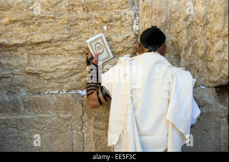 JERUSALEM, ISRAEL - 6. Oktober 2014: Ein jüdischer Mann mit der Thora in seiner Hand ist an der westlichen Wand in der Altstadt von beten Stockfoto