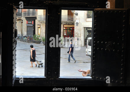 Ein Bettler sitzt in der Tür Weg einer Kirche, Barcelona. Basílica De La Mercé Spanien Stockfoto