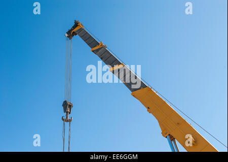 Große erweiterte Industriekran Klüverbaum Arm vor dem blauen Himmelshintergrund Stockfoto