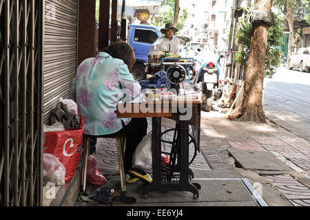 Frau mit Vintage Pedal Nähmaschine auf der Straße, Bangkok, Thailand, Südostasien. Stockfoto