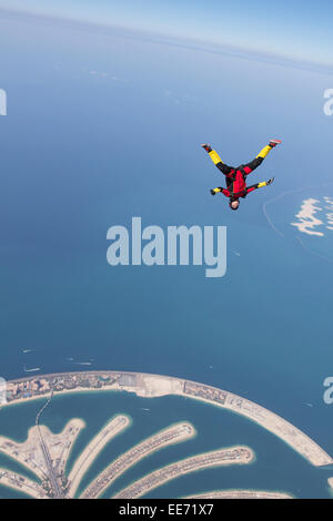 Fallschirmspringer hat Spaß und Kopf nach unten fliegen kostenlos mit einer Geschwindigkeit von 125 km/h auf 10'000 Fuß Höhe über Dubai Palmenstränden. Stockfoto