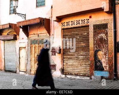 Mann gekleidet in traditionellen Kleidungsstück zu Fuß auf der Straße in den frühen Morgenstunden - Marrakesch, Marokko Stockfoto