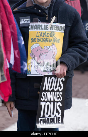 Ein junger Mann mit einem Slogan und Charlie Hebdo Abdeckung während sammeln "Je Suis Charlie" Mahnwache an Laval Stadt, Jet d ' Eau Square, Su Stockfoto