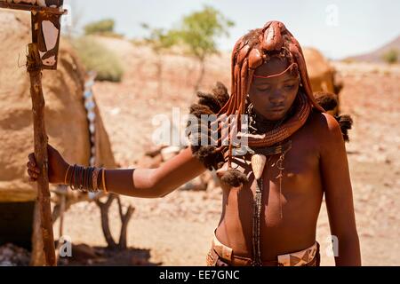 Eine junge Frau, die Zugehörigkeit zu den Ureinwohnern der Himba in ihrem Dorf im Norden Namibias abgebildet. Stockfoto