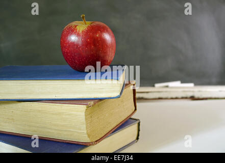roter Apfel auf Haufen von Schulbüchern Stockfoto