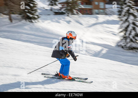 Kinder tragen Skihelm Skifahren auf der Piste im Wintersportort in den Alpen Stockfoto