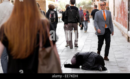 Menschen zu Fuß vorbei an Obdachlose betteln im Stock. Venedig, Italien Stockfoto