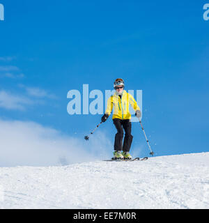 Ältere weibliche Skifahrer Ski Helm Skifahren auf der Piste im Wintersportort in den Alpen Stockfoto