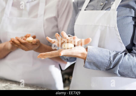 Weibliche Köche machen Pasta Teigkugeln In Küche Stockfoto