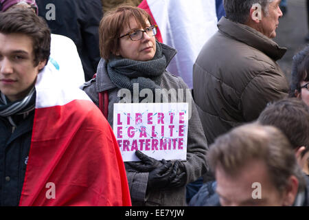 Eine Frau mit einem Slogan, die Werte der französischen Republik: Freiheit, Gleichheit, Brüderlichkeit während sammeln "Je Suis Charlie" Vigil Stockfoto