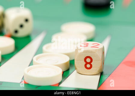 Stücke und ein Würfel auf einem Backgammon-Brettspiel Stockfoto