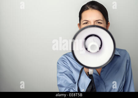 Frau spricht über ein Megaphon, da sie eine öffentliche Adresse macht beteiligt sich an einem Protest oder organisiert eine Rallye oder promotion Stockfoto