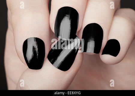 Auf weibliche Hände mit schwarzem Nagellack Maniküre Stockfoto