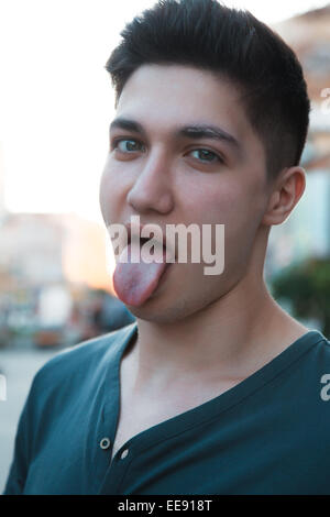 attraktive junge Mann zeigt seine Zunge Stockfoto
