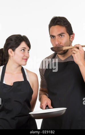 junges attraktives Paar Köche tragen schwarze Schürze Stockfoto