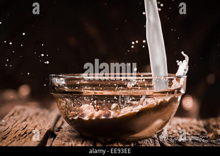 Milch in Schüssel mit Schokokugeln gießen. Stockfoto