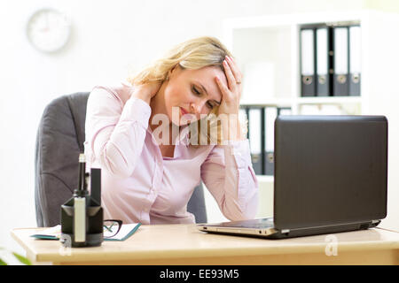 Business-Frau mit Kopfschmerzen, die mit Stress im Büro Stockfoto