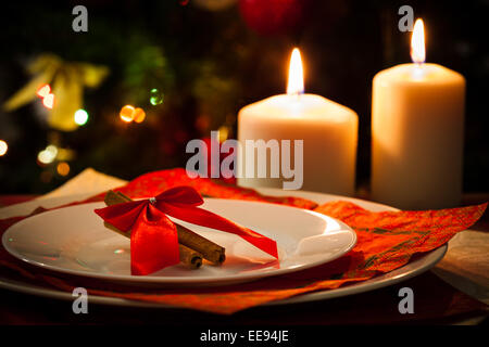 Weihnachts-Dekoration, Kerzen, Zimtstangen und Stücke von Orange auf Weihnachtsbaum Hintergrund Stockfoto