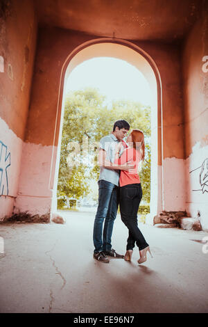 Junges Paar in der Liebe. Sie sind küssen. Winterwald und alte Bogen als Hintergrund. Stockfoto