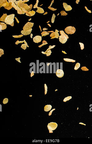 Fliegende Cornflakes auf schwarzem Hintergrund isoliert Stockfoto