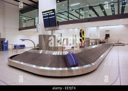 Eine einzige Tasche ist links drehen auf einem Gepäck Reclaim Förderband in einen verlassenen Gepäckhalle zurückfordern. Gatwick Nord-Terminal Stockfoto