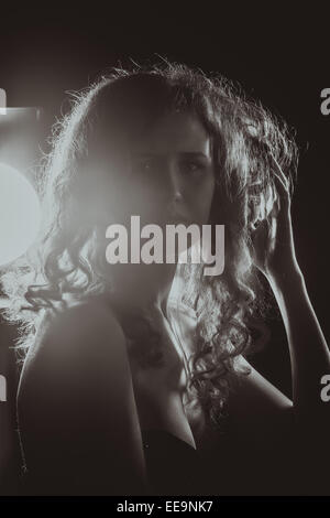Ein schwarz-weiß Bild eine schöne junge Frau mit wehenden Haaren. Film-Noir-Stil. Gefiltert Stockfoto