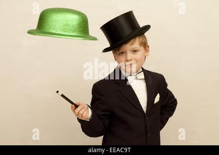 kleiner Junge verkleidet als Magier machen einen Hut schweben in der Luft Stockfoto