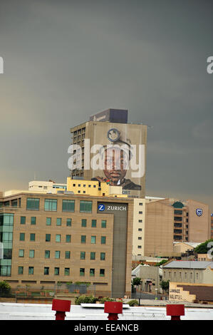 Aus der Ferne betrachtet ein Bergarbeiter-Gesicht auf einem Wolkenkratzer in Johannesburg Central Business District. Stockfoto