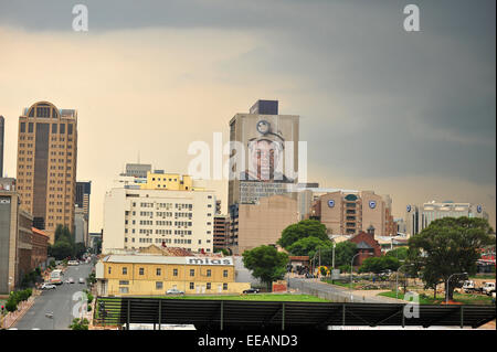 Aus der Ferne betrachtet ein Bergarbeiter-Gesicht auf einem Wolkenkratzer in Johannesburg Central Business District. Stockfoto