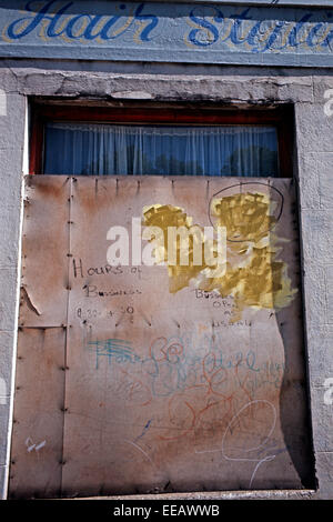 BELFAST, NORDIRLAND - MAI 1973. Mit Brettern vernagelt Shop Front mit Unternehmen wie gewohnt lackiert Zeichen während der Unruhen, Nordirland. Stockfoto