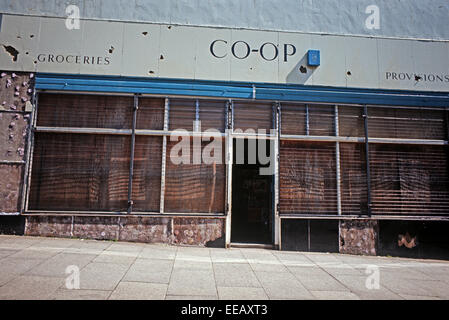 BELFAST, NORDIRLAND - MAI 1973. Mit Brettern vernagelt Shop Front mit Unternehmen wie gewohnt lackiert Zeichen während der Unruhen, Nordirland. Stockfoto