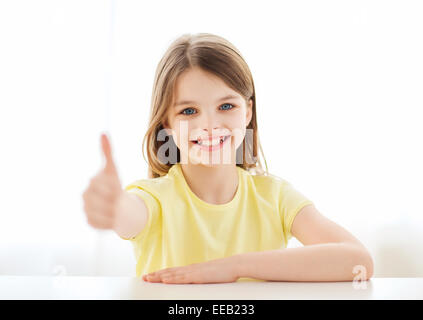 wunderschönes kleines Mädchen zu Hause auftauchen Daumen Stockfoto