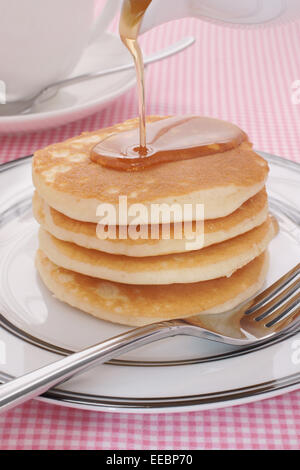 Ahornsirup auf Buttermilch Pfannkuchen gießen Stockfoto