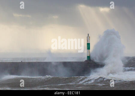 Aberystwyth, Wales, UK. 15. Januar 2015. UK-Wetter: noch kommt ein anderes Wettersystem vom Atlantik bringen starke Winde, Wellen gegen die Hafenmauer in Aberystwyth, während Sonnenstrahlen unter drohenden Gewitterwolken ausgehen. Bildnachweis: Alan Hale/Alamy Live-Nachrichten Stockfoto