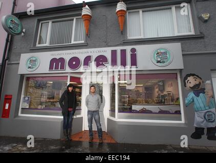 Ballycastle, Nordirland, Vereinigtes Königreich. 14. Januar 2015. Romeo und Deidre Morelli außerhalb ihrer Welt berühmten Eisdiele in Ballycastle, Nordirland, wo sie gegenüberstehen Strafverfolgung für die Errichtung der "Morelli" unterzeichnen (abgebildet) Planungsservice zwingen sie, nehmen Sie ihre Leuchtreklame von Anfang Februar oder im Gesicht Heafty Geldstrafen in Höhe von £2500 und £250 pro Tag nach einem bestimmten Datum... Bild STEVEN MCAULEY/MCAULEY MULTIMEDIA * Nummer Hundefigur erfragen die paar * Credit: Steven McAuley/Alamy Live News Stockfoto