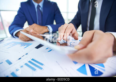 Geschäftsmann zeigte auf Touchscreen während der Interaktion mit seinem Partner Tagung Stockfoto